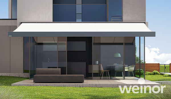 Außensicht Haus mit mit ausgefahrenen Markisen auf Terrasse und Balkon